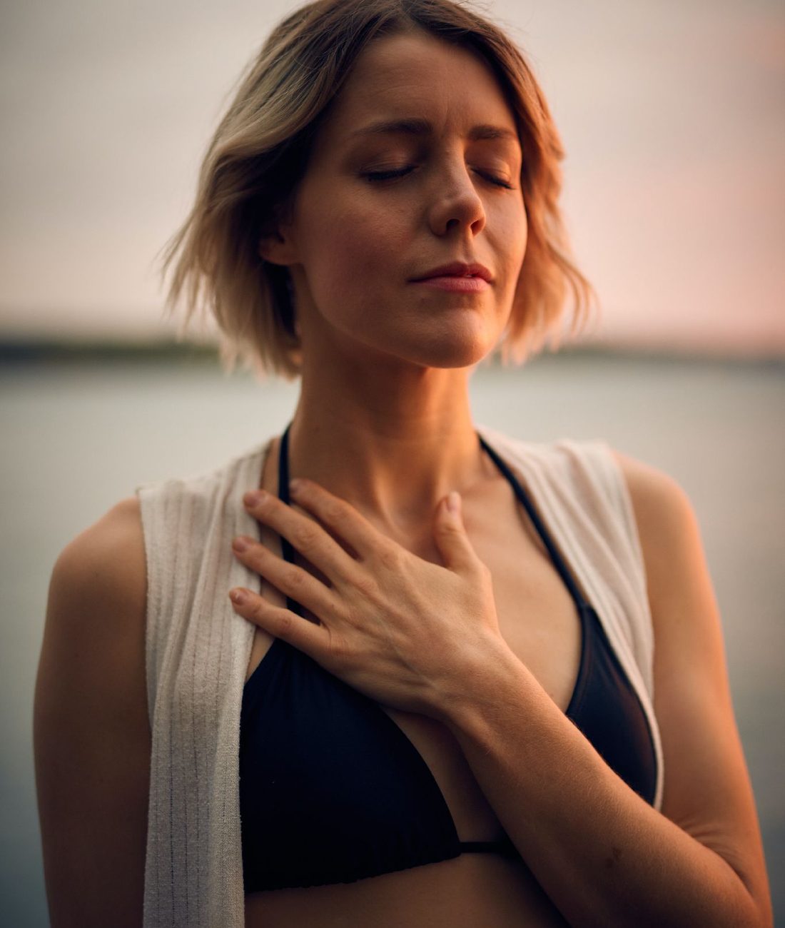 Mujer con la mano en el pecho, respirando
