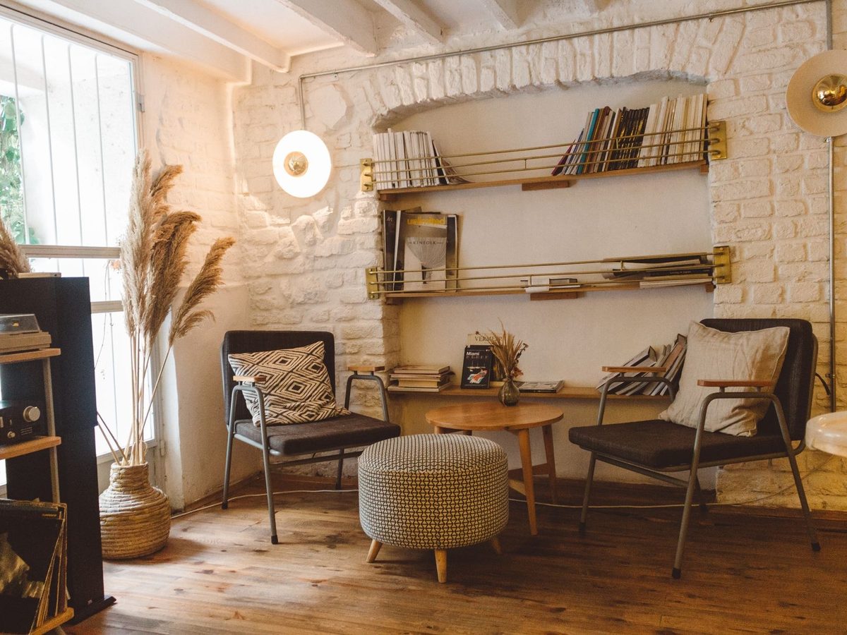 Sala de espera con butacas, estantería y luz natural