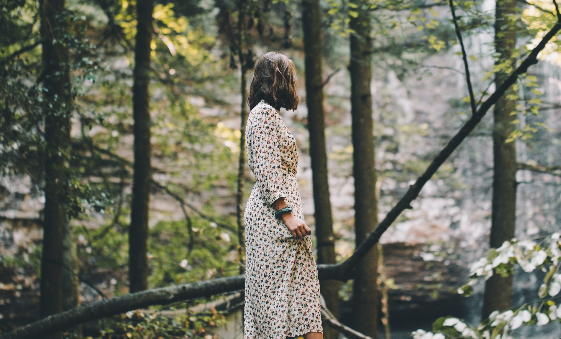Mujer caminando entre árboles en un bosque