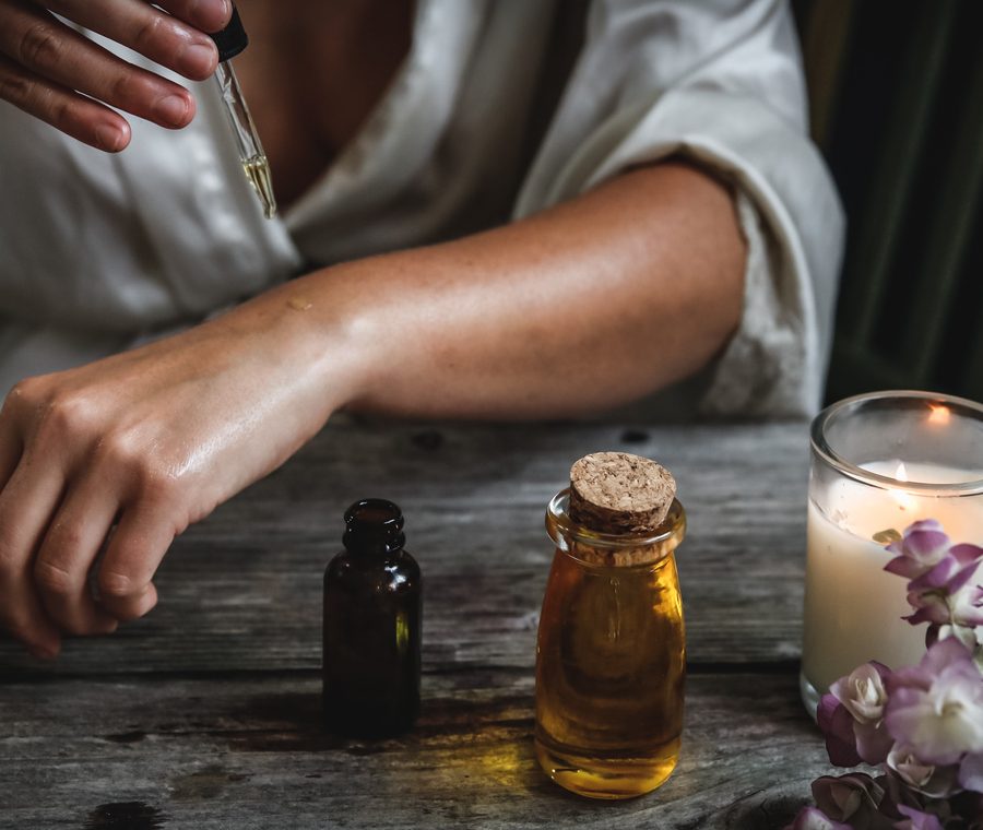 Manos con aceite esencial y vela